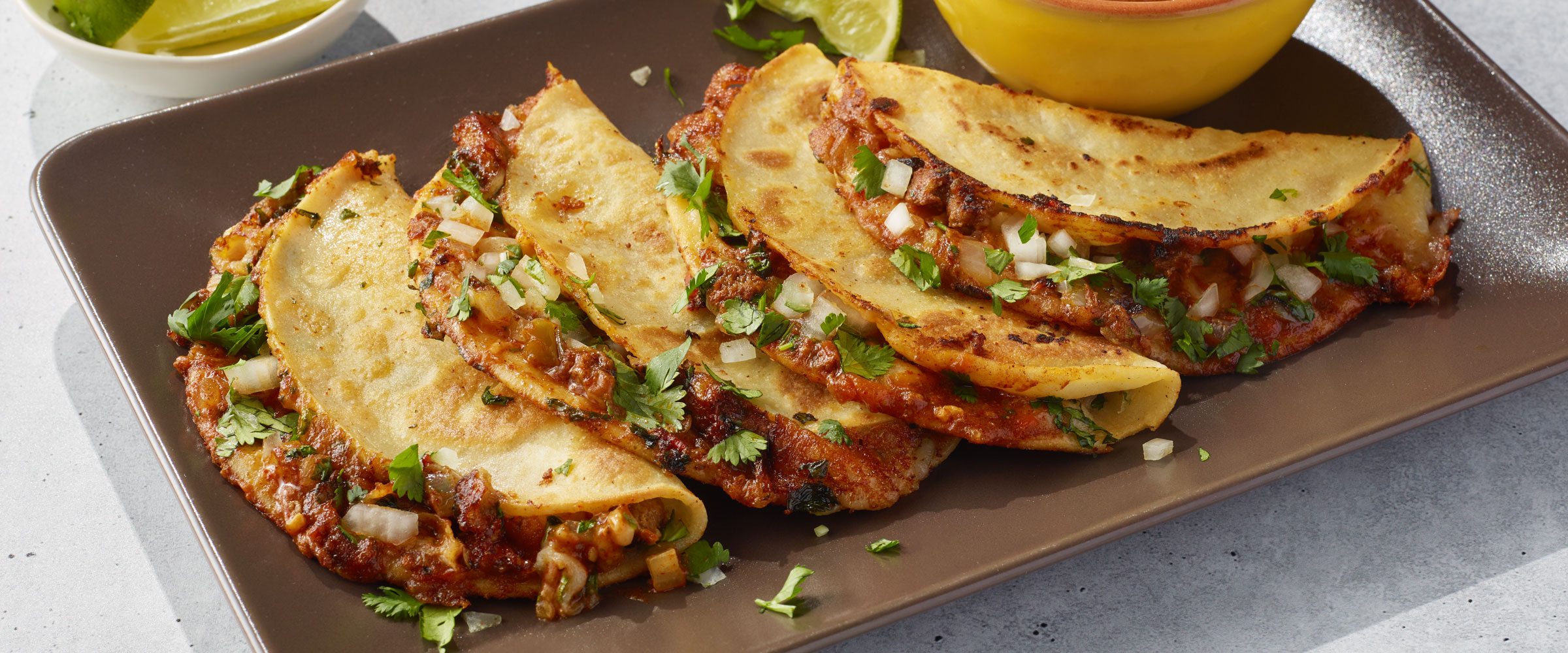 Birria tacos with cilantro, lime, and fresh toppings