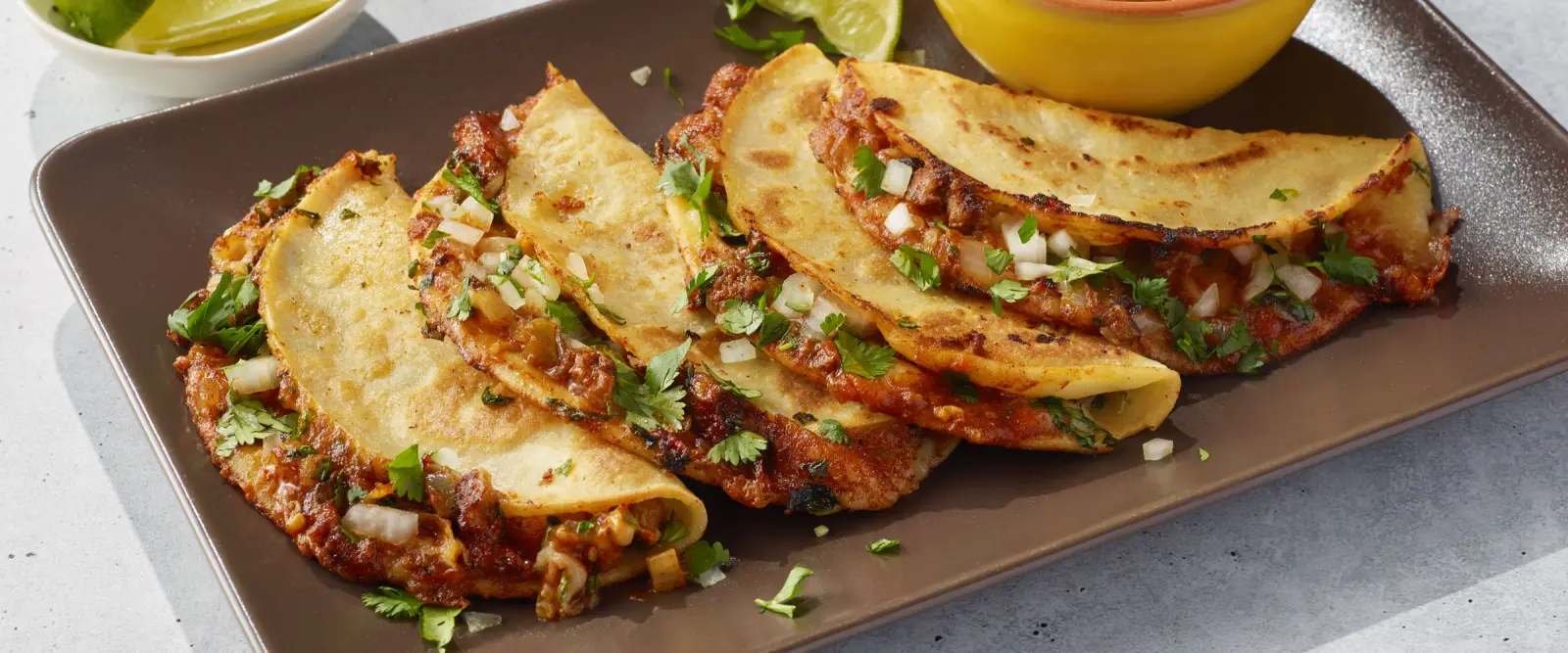 Birria tacos with cilantro, lime, and fresh toppings