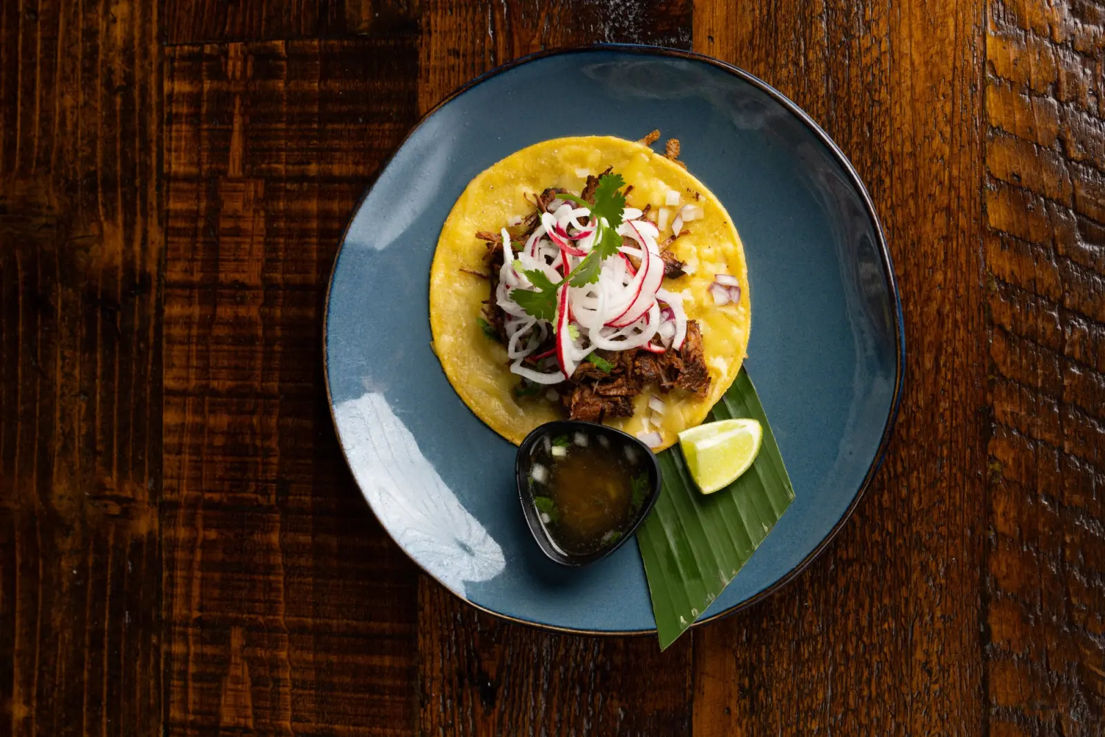Editorial-style birria taco plating with garnishes