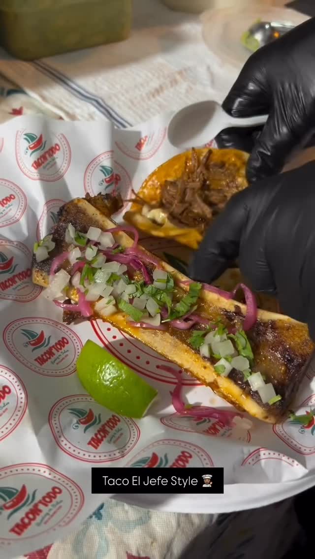 Closeup of a signature TacoNTodo birria taco with bone marrow on branded paper